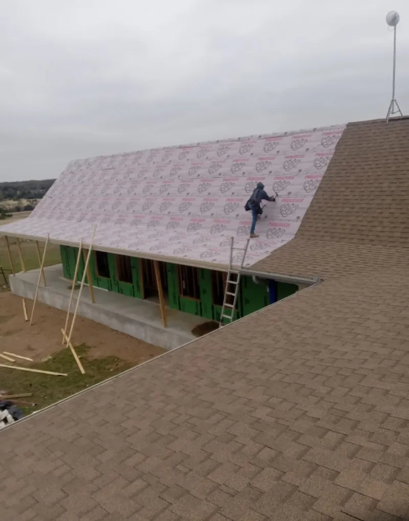Worker preparing underlayment for a metal roof installation in Brooklyn Park